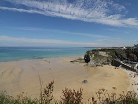 A beach with cliffs and sea at Sea Snug in Newquay
