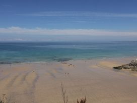 A beach with people walking near the water at Sea Snug in Newquay