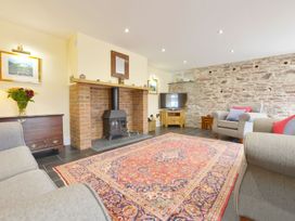 A living room with a fireplace and television at The Cider Barn at Home Farm Down Thomas near Wembury