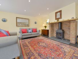 A living room with a sofa and fireplace at The Cider Barn at Home Farm Down Thomas near Wembury