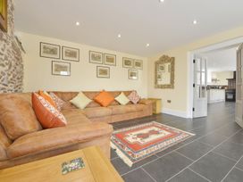 A living room with a sofa and artwork at The Cider Barn at Home Farm Down Thomas near Wembury