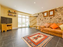 A living room with a sofa and television at The Cider Barn at Home Farm Down Thomas near Wembury