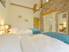 A bedroom with two beds and a lamp at The Cider Barn at Home Farm in Down Thomas near Wembury