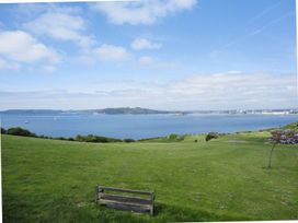 A view of a water body with boats and a bench at The Cider Barn at Home Farm Down Thomas near Wembury