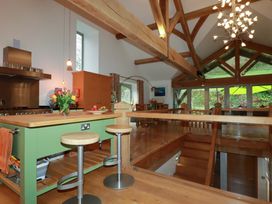 A kitchen with a green island and wooden beams at Kerslake House in Crafthole