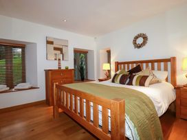 A bedroom with wooden furniture and a bed at Kerslake House Crafthole