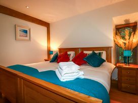 A bedroom with a bed and nightstand at Kerslake House Crafthole