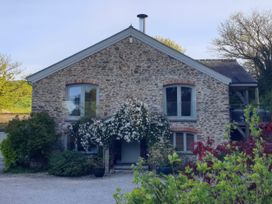 A stone house with windows and plants at Kerslake House in Crafthole
