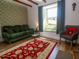 A living room with a sofa and armchair at Halwyn Farm in Helston