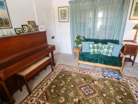 A living room with a piano and a sofa at Halwyn Farm in Helston