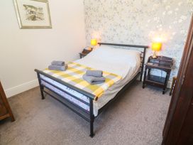 A bedroom with a bed and bedside tables at Halwyn Farm in Helston
