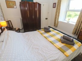A bedroom with a bed and wardrobe at Halwyn Farm in Helston