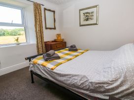 A bedroom with a bed and window at Halwyn Farm in Helston