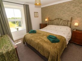 A bedroom with a bed and bedside tables at Halwyn Farm in Helston