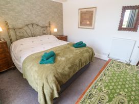 A bedroom with a bed and bedside table at Halwyn Farm in Helston
