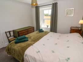 A bedroom with a bed and dressing table at Halwyn Farm in Helston