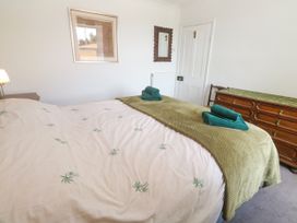 A bedroom with a bed and towels at Halwyn Farm in Helston