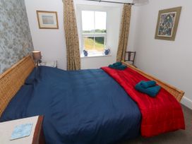 A bedroom with a bed and a window at Halwyn Farm in Helston