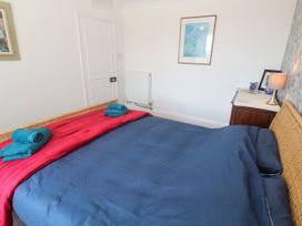 A bedroom with a bed and dresser at Halwyn Farm in Helston