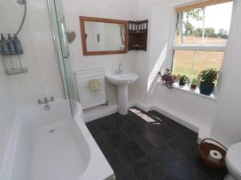 A bathroom with a bathtub and sink at Halwyn Farm in Helston