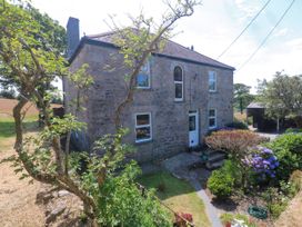 A stone house with garden plants and steps at Halwyn Farm in Helston