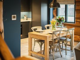 A dining area with wooden table and flowers at The Lookout in Addingham