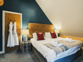 A bedroom with a bed and robes hanging at The Lookout in Addingham