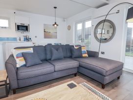 A living room with a sofa and coffee table at Pentewan in Redruth