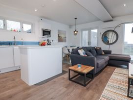 A living room with a sofa and kitchen island at Pentewan in Redruth
