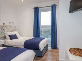 A bedroom with two beds and a window at Pentewan in Redruth