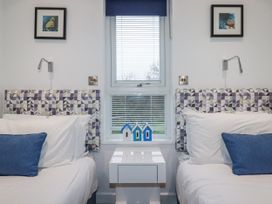 A bedroom with two beds and decorative items at Pentewan in Redruth