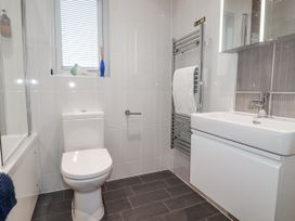 A bathroom with a toilet, sink, towel radiator, and bathtub at Pentewan in Redruth