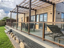 A wooden deck with table and chairs at Pentewan Redruth