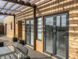 An outdoor seating area with sliding doors and a table at Pentewan in Redruth