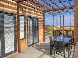An outdoor patio with a dining table and chairs at Pentewan in Redruth