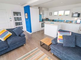 A living room with sofas and kitchen units at Pentewan - 67 Portreath
