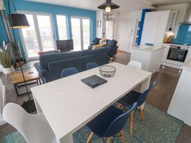A living room with a sofa and dining area at Pentewan - 67 Portreath