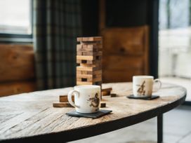 A living room with coffee cups and a wooden block game at Bears Den in Addingham