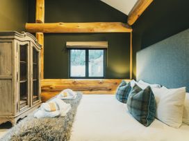 A bedroom with a bed and cabinet at Bears Den in Addingham