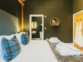 A bedroom with a bed and bathroom visible at Bears Den in Addingham