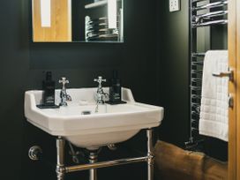 A bathroom with a sink and towel rack at Bears Den in Addingham