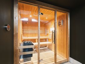 A sauna with wooden benches and a temperature control panel at Bears Den in Addingham