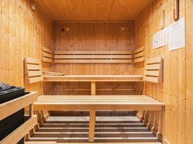 A sauna with wooden benches and a stone heater at Bears Den in Addingham