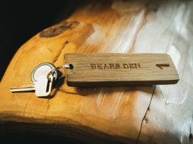 A key with a wooden tag labeled Bears Den