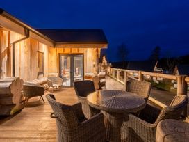 An outdoor deck area with a table and chairs at Bears Den in Addingham
