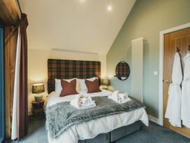 A bedroom with a bed and bedside lamps at Keepers Cabin Addingham