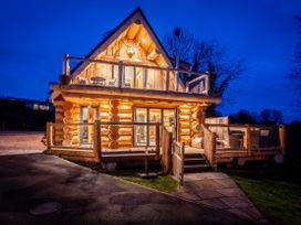 A log cabin with a deck and lighting at Keepers Cabin Addingham