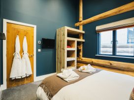 A bedroom with a bed and towels at The Farmhouse in Addingham