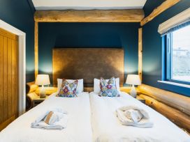 A bedroom with a bed and lamps at The Farmhouse in Addingham