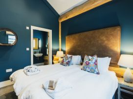 A bedroom with two beds and a mirror at The Farmhouse in Addingham